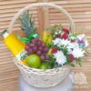 Хризантемы, розы и фрукты в плетеной корзине
